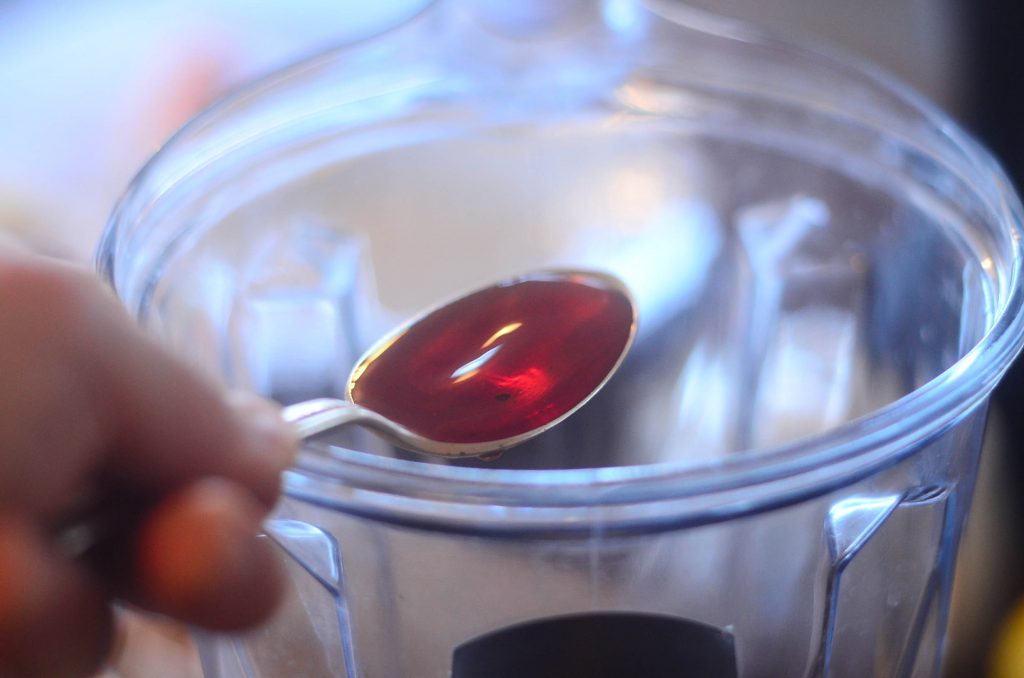 spoonful of red wine vinggar being poured into blender 
