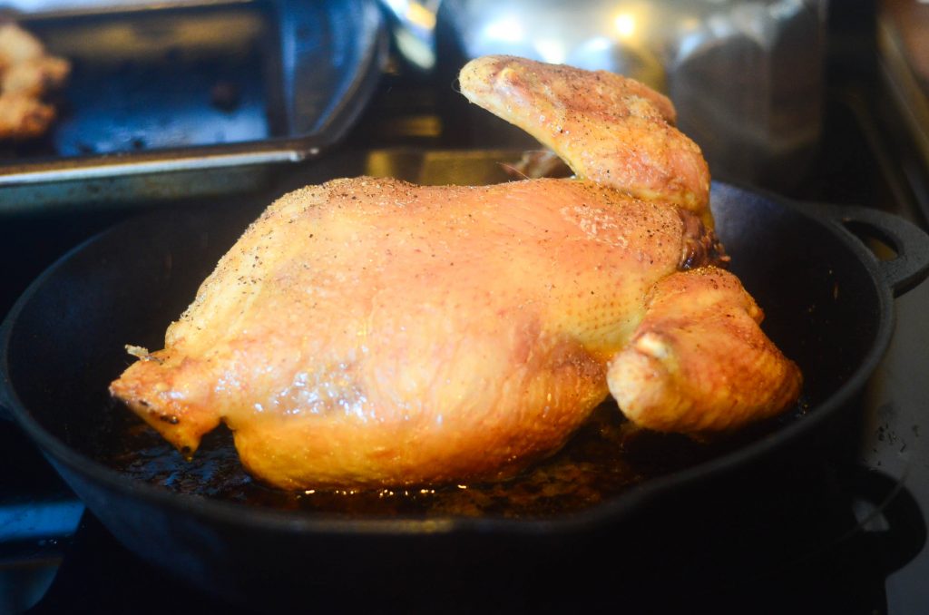 chicken roasting in a cast-iron skillet